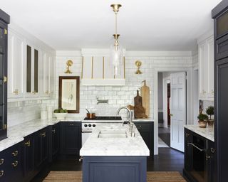 Small white kitchen ideas with white and dark blue cupboards and a white gloss subway tile all-over backsplash
