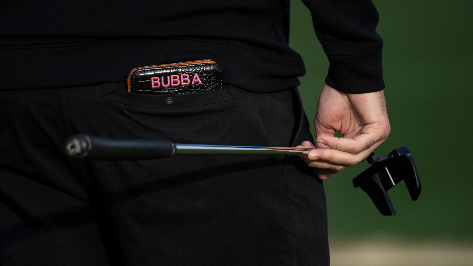 A close up Bubba Watson's putter and yardage book