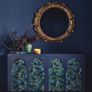 Anthropologie House of Hackney Six-Drawer Dresser against a navy wall with a gold mirror,
