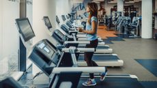 Woman walking on treadmill in empty gym