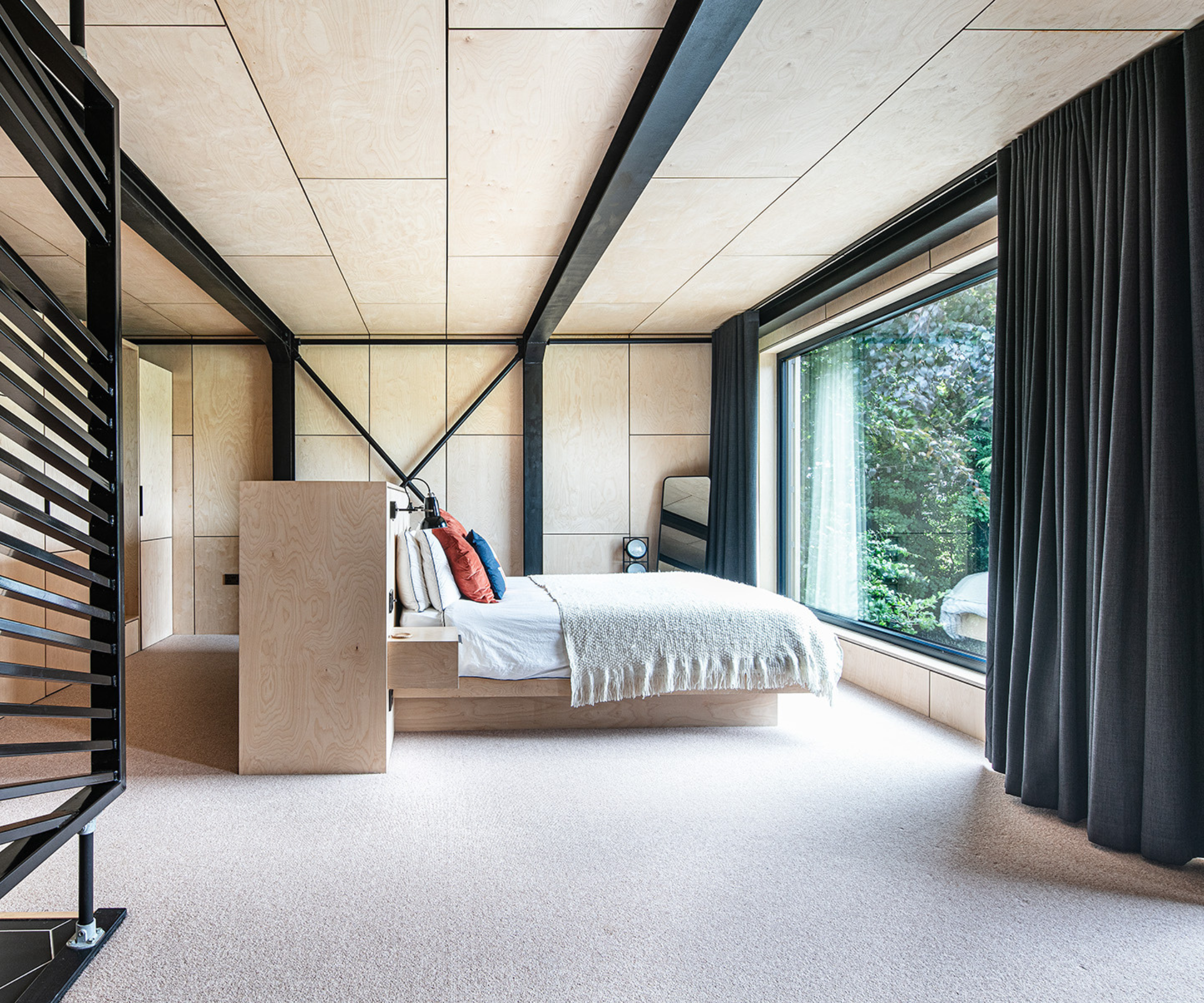 Bedroom with the bed facing a large window overlooking the garden