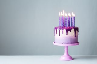 birthday cake with candles on a cake stand