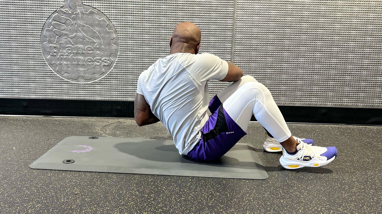 Teddy Savage completing a dumbbell sit-up Russian twist