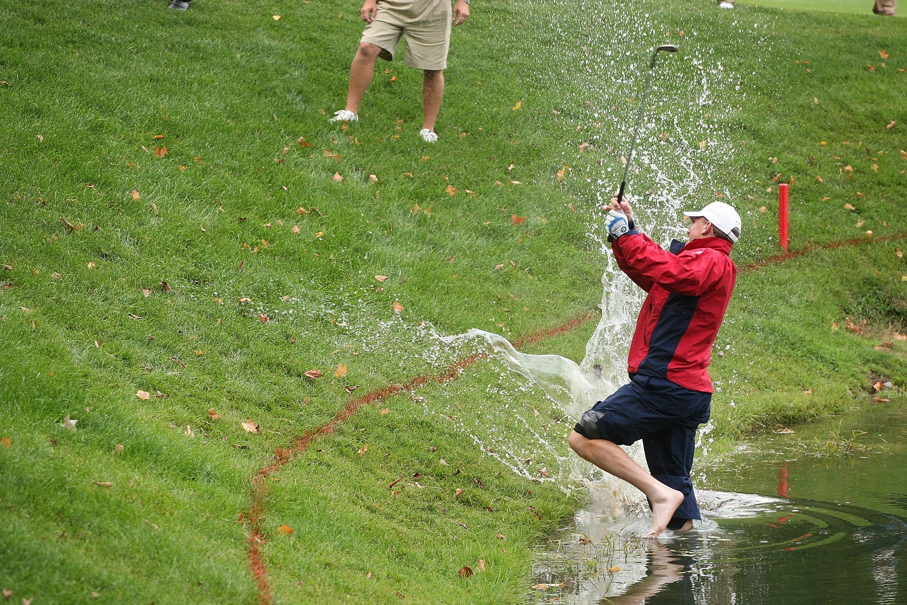 Woody Austin hitting a shot from the water and being splashed at the Presidents Cup in 2007