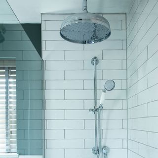 bathroom with white walled tiles and round shower