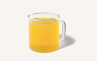 A glass mug of yellow tea; Starbucks Emperor's clouds and mist tea