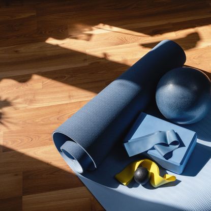blue at-home pilates equipment on a wooden floor