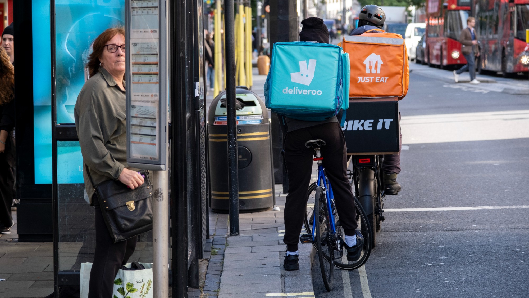 Deliveroo and Just Eat takeaway delivery cycle couriers on Oxford Street