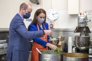 Prince William, Duke of Cambridge and Catherine, Duchess of Cambridge help prepare meals