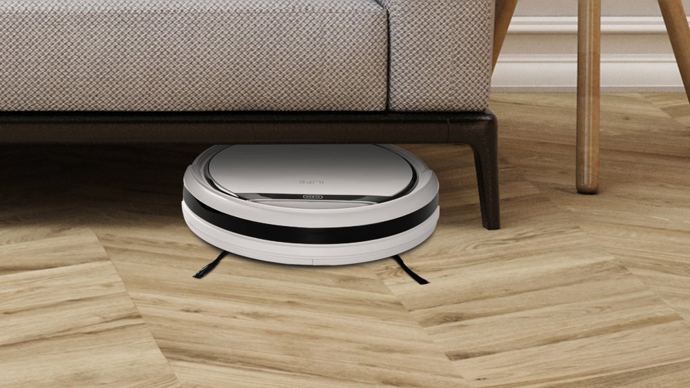 The iLife V3s Pro robot vacuum fitting under a sofa to collect dust