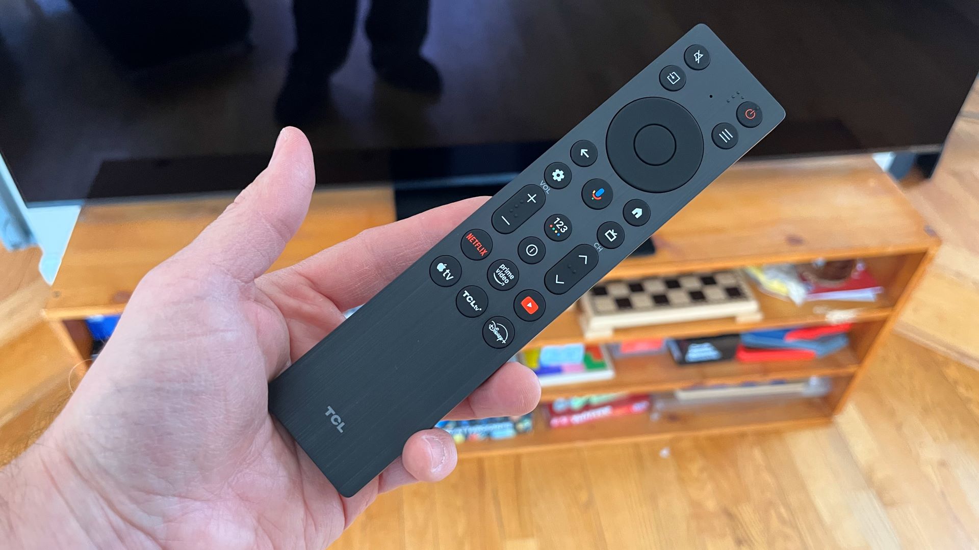 TCL QM7K remote control held in hand
