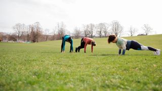 Three women doing planks in local park