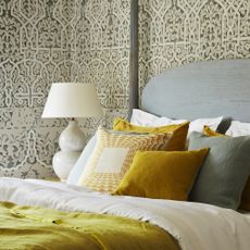 four poster bed with grey patterned wallpaper