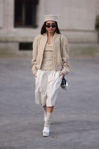 woman wearing cardigan, shirt, bermuda shorts, tights, and heels