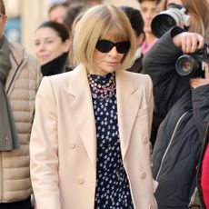 Anna Wintour wears a polka dot dress and beige coat