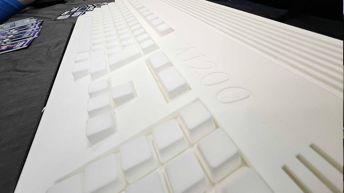Close up of White Amiga A1200 prototype keyboard and logo on black table at Gamescom 2025.