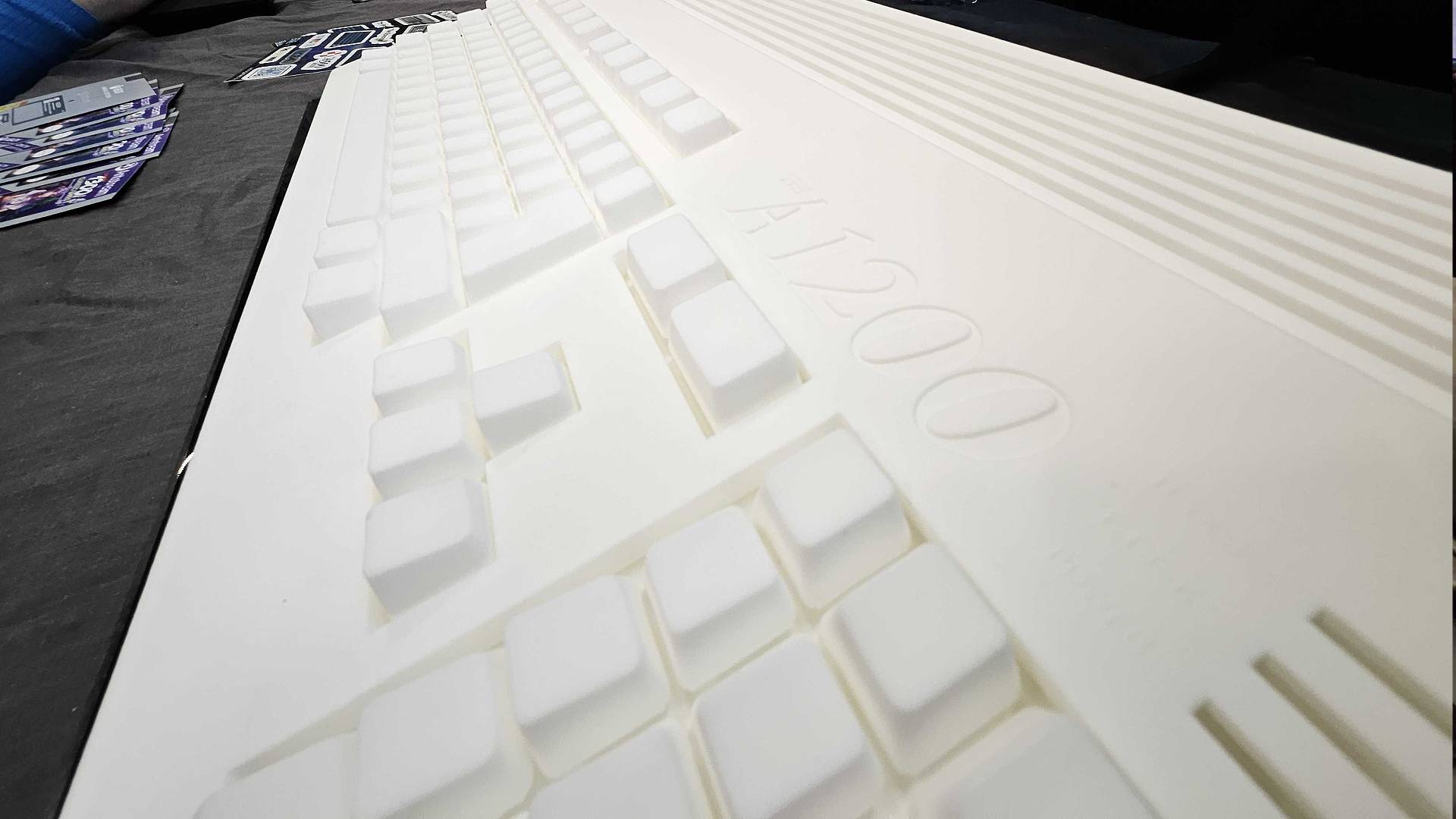 Close up of White Amiga A1200 prototype keyboard and logo on black table at Gamescom 2025.