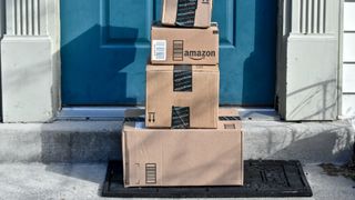 Paket från Amazon staplade utanför blå dörr