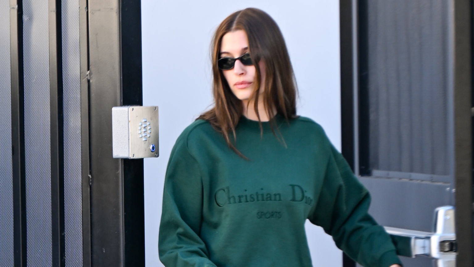 a woman with brown hair in a green sweatshirt