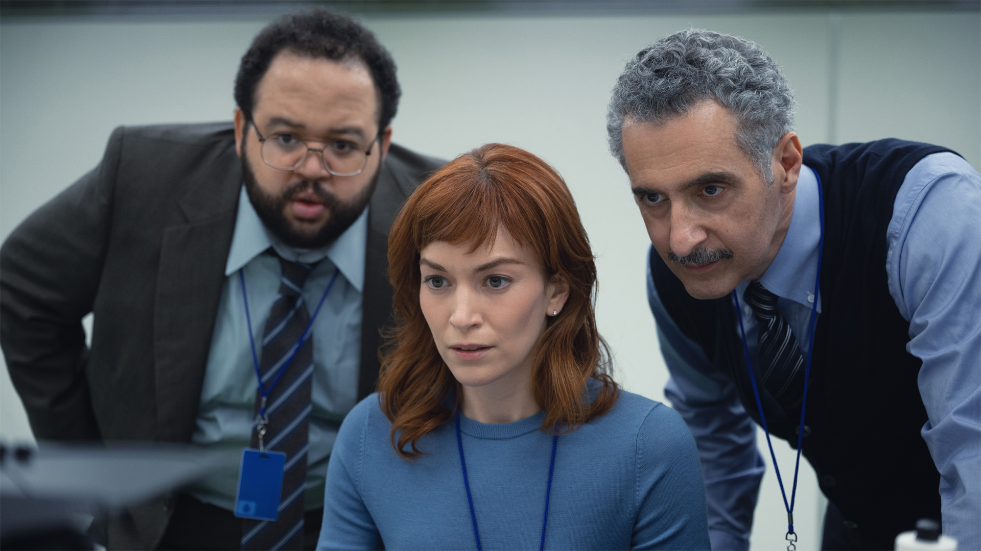 Dylan G, Helly R and Irving B looking at a computer in Apple TV Plus's Severance.