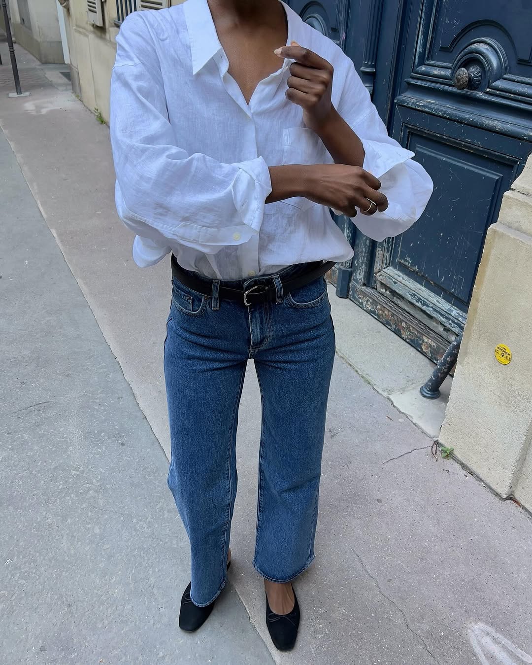 Woman wearing tailored jeans and ballet flats.