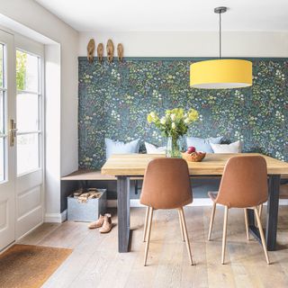 dining room with William Morris wallpaper and yellow pendant light