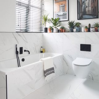 bathroom with white tiled flooring and white bathtub