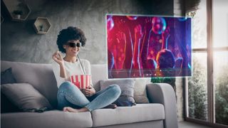 A person wearing the Lenovo Glasses T1 on a couch, using them to watch a show while eating popcorn