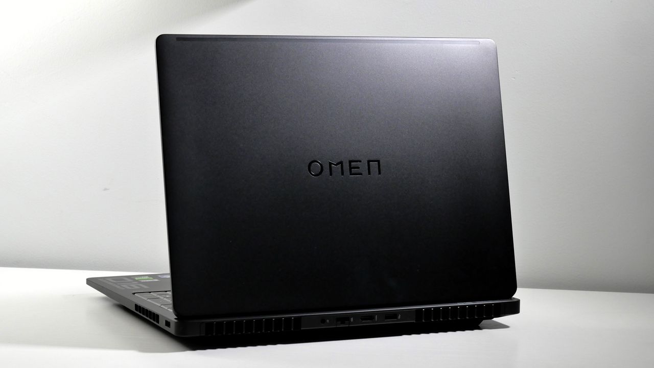 HP Omen Max 16 open on a white desk, highlighting its black lid and glossy black Omen logo.