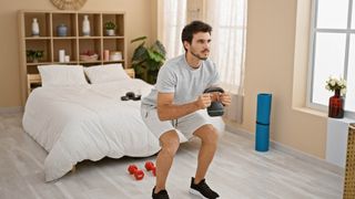 Man working out with weights in bedroom