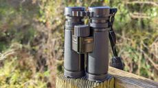 Nikon Monarch HG 10x42 binoculars placed on a fence post