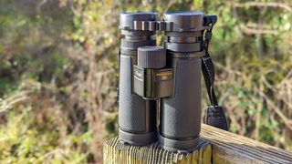 Nikon Monarch HG 10x42 binoculars placed on a fence post