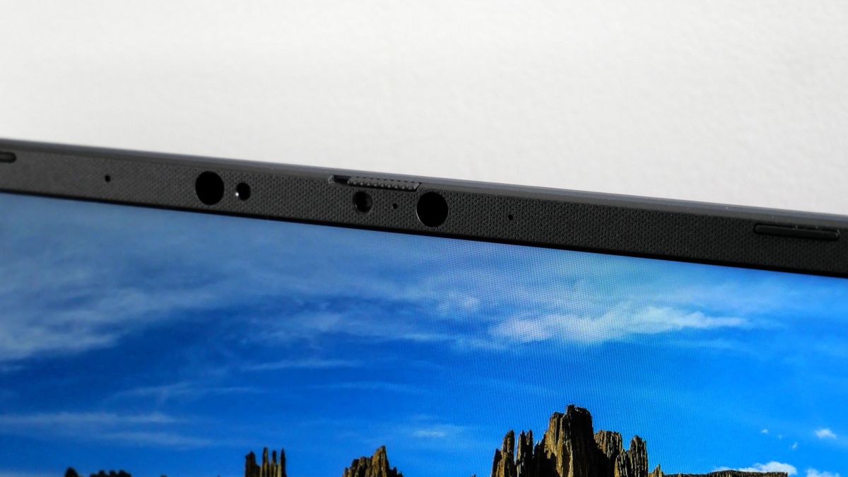 Asus Vivobook 16 (2025) open and powered on against a light gray background, highlighting the webcam with its privacy shutter.