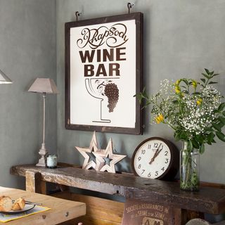 grey wall kitchen with wooden vintage table, flower vase and lamp