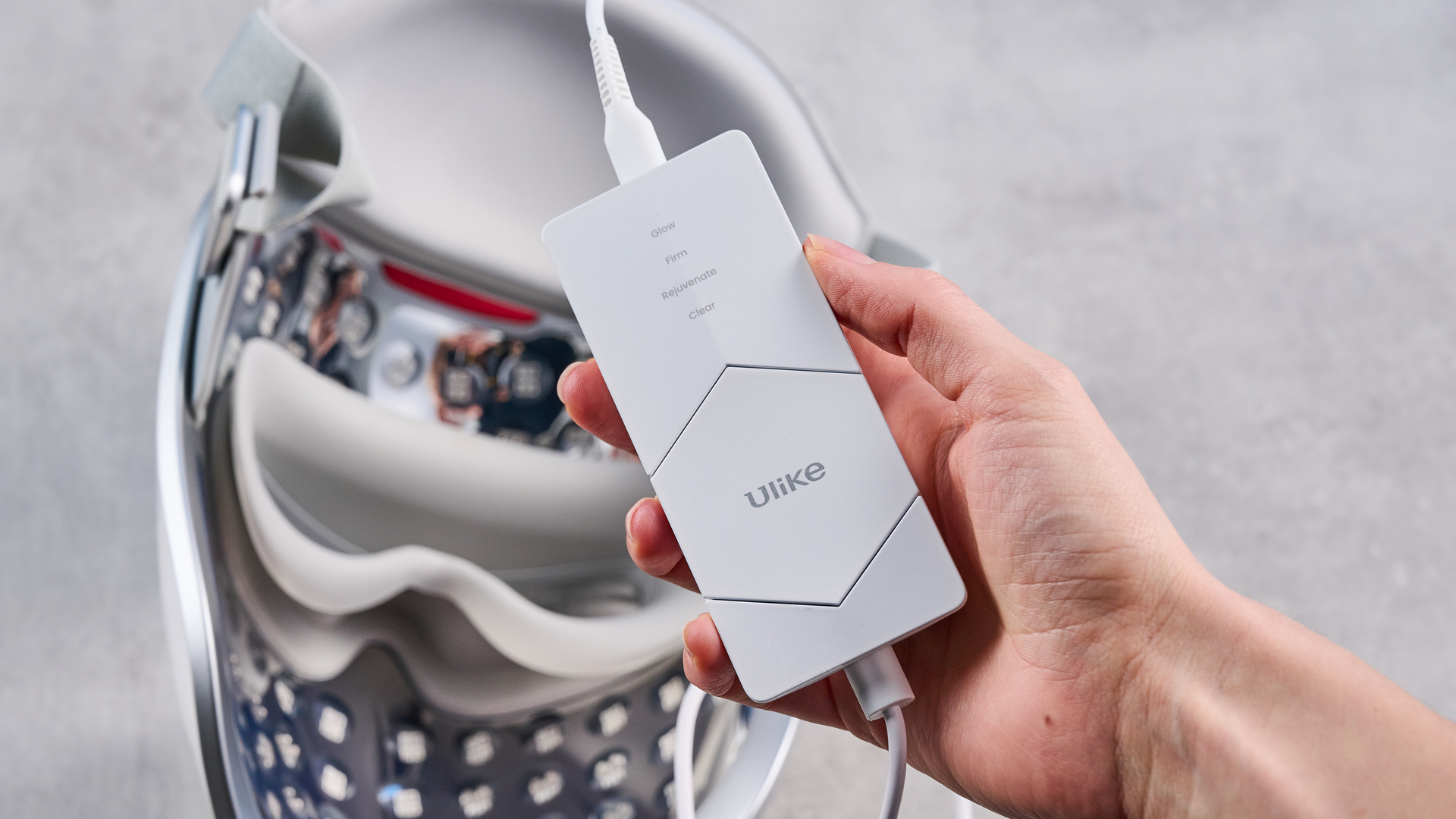 the ulike reglow led skincare mask showing its red LED light and control and charger