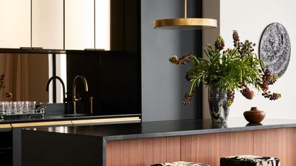 How to mix metals: black kitchen with dark wood breakfast bar and gold pendants