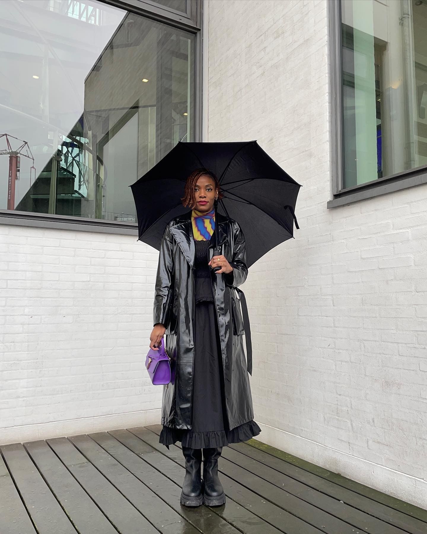 A woman with an asymmetrical bob standing under an umbrella