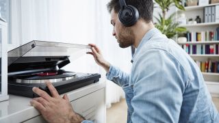 Should I wait until Black Friday to buy a record player?: Man listening to music on a record player
