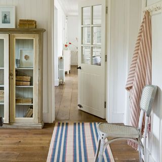 hallway area with white walls and wooden flooring