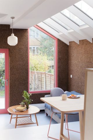 Living area in extended space with cork walls and pink window frames