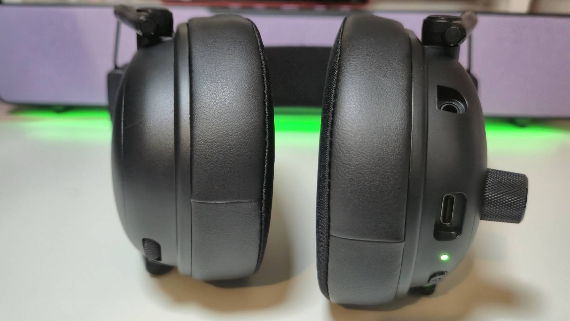 Photo by Rosalie Newcombe of the earcups of the Razer BlackShark V3 gaming headset sitting on a white desk.