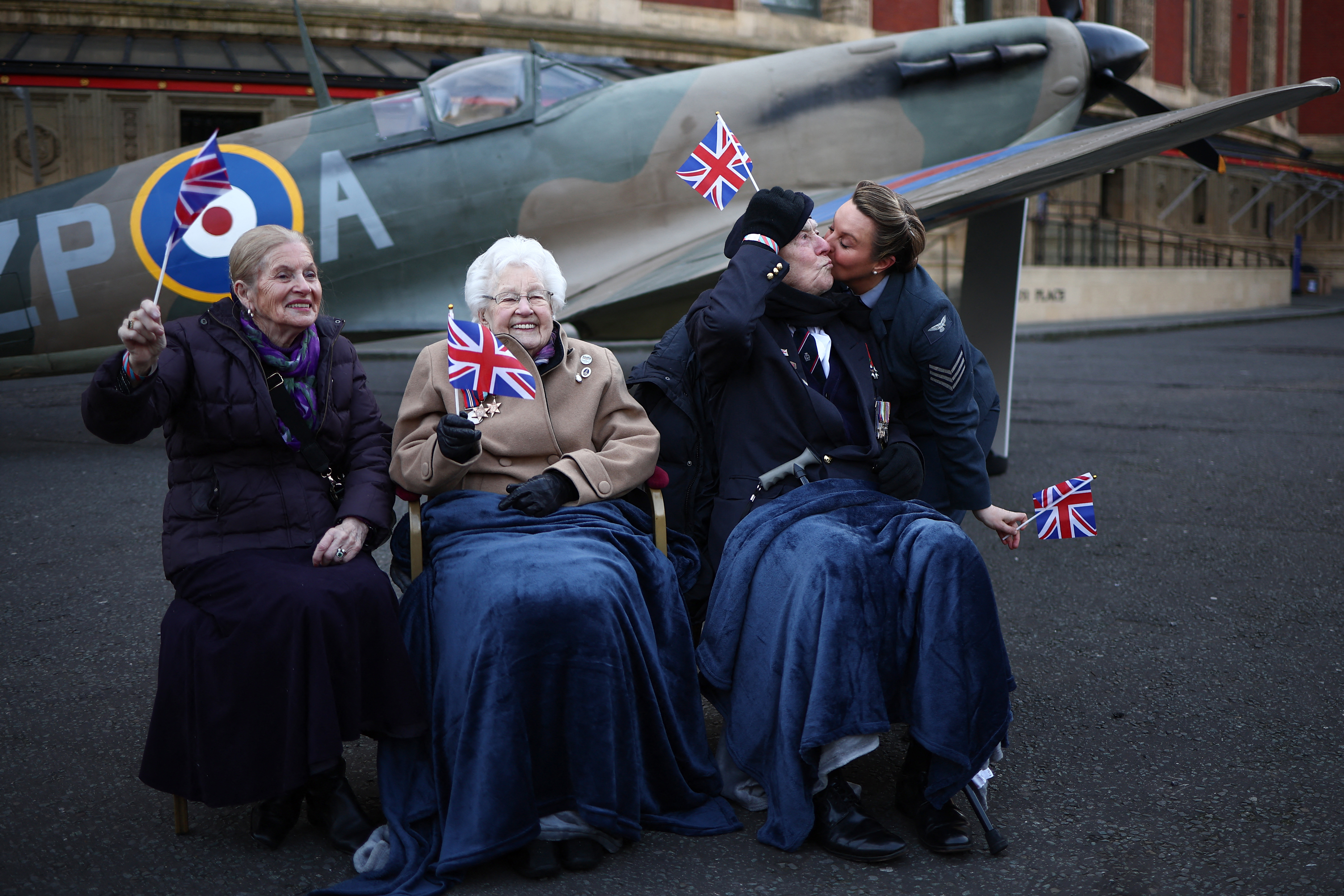 people with flags in from of a plane