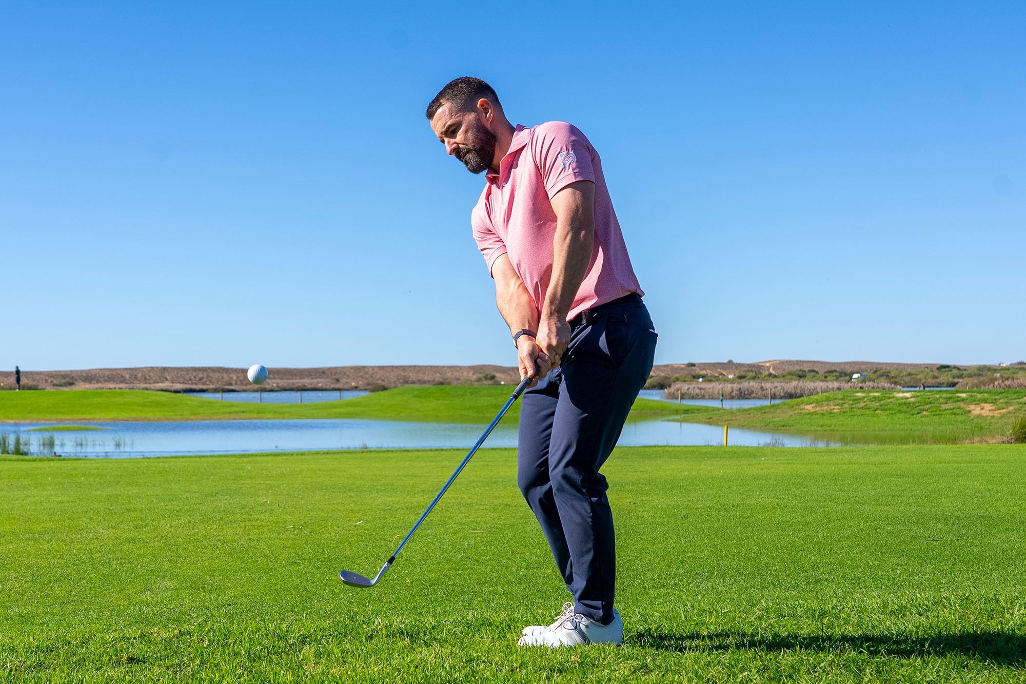 James Jankowski just past impact with the golf ball popping out of the rough after James successfully read the lie and adapted his technique accordingly