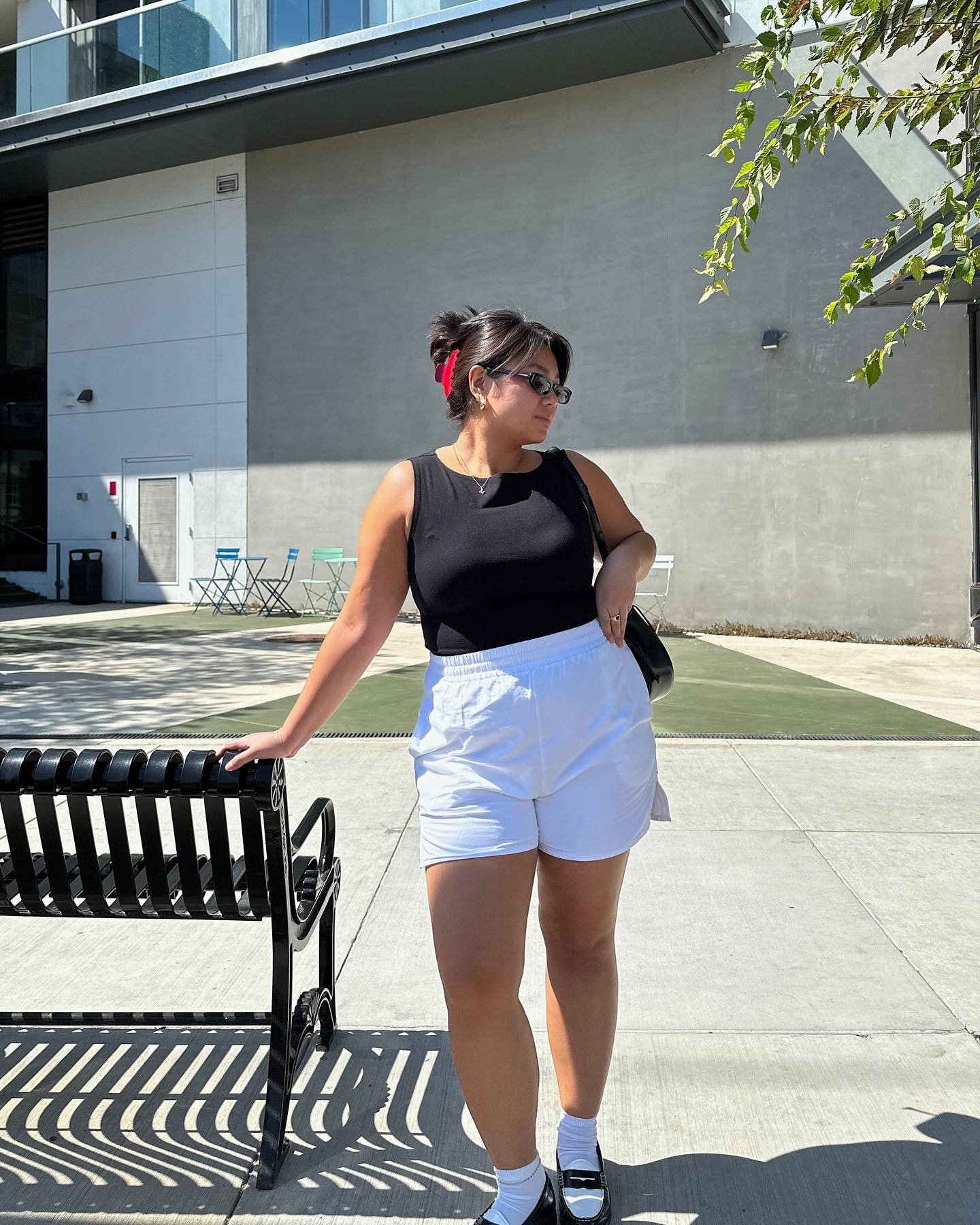 A woman wears a black tan, white boxer shorts, white socks and loafers.
