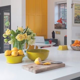 Kitchen island with bowl of lemons and vase of flowers