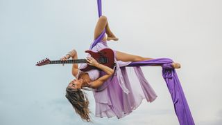 Andrea Krakovsk&aacute; plays an ESP guitar while in the midst of one of her aerial routines