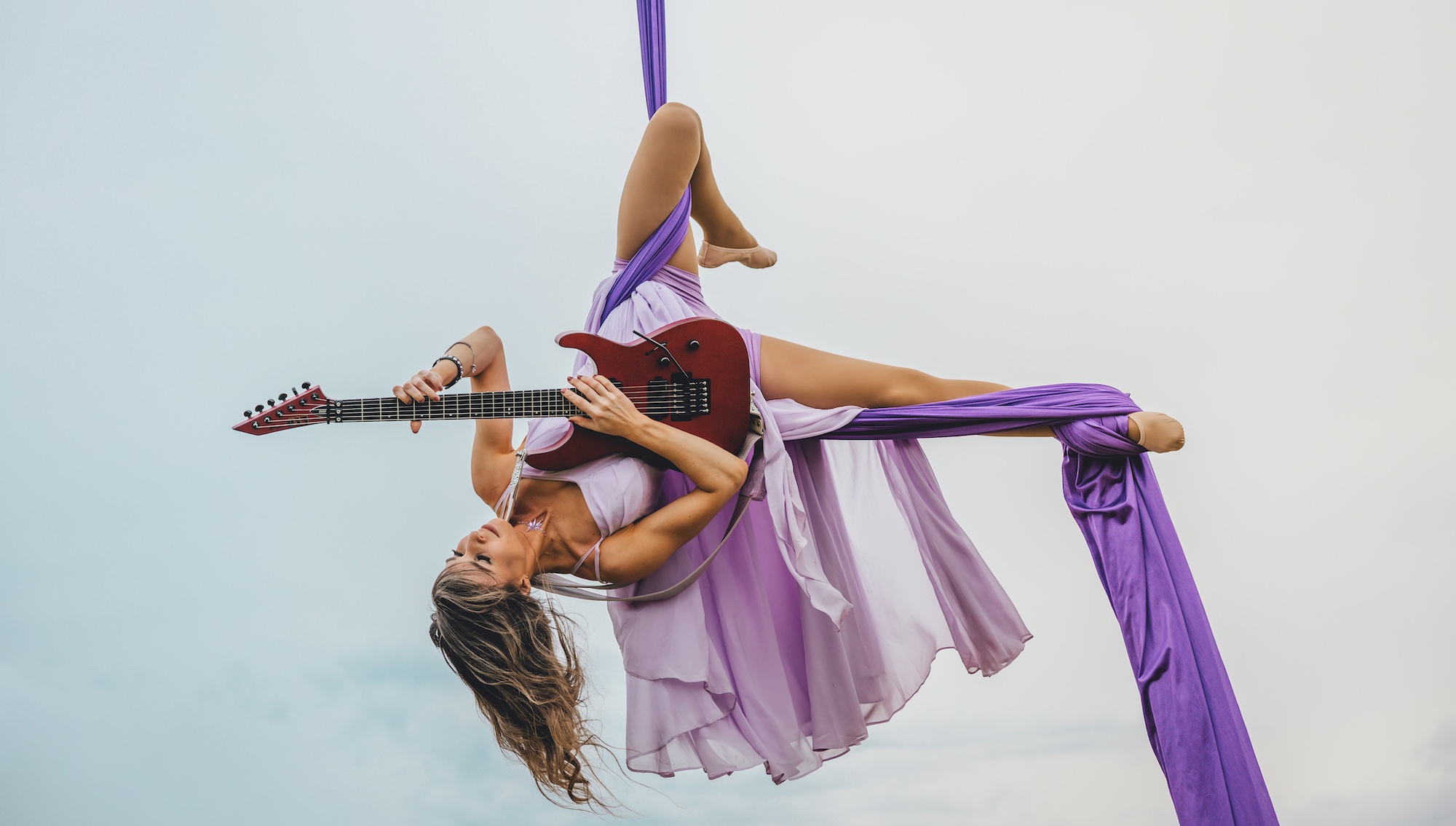 Andrea Krakovsk&aacute; plays an ESP guitar while in the midst of one of her aerial routines