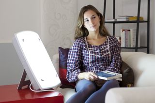 Woman using light therapy for seasonal affective disorder