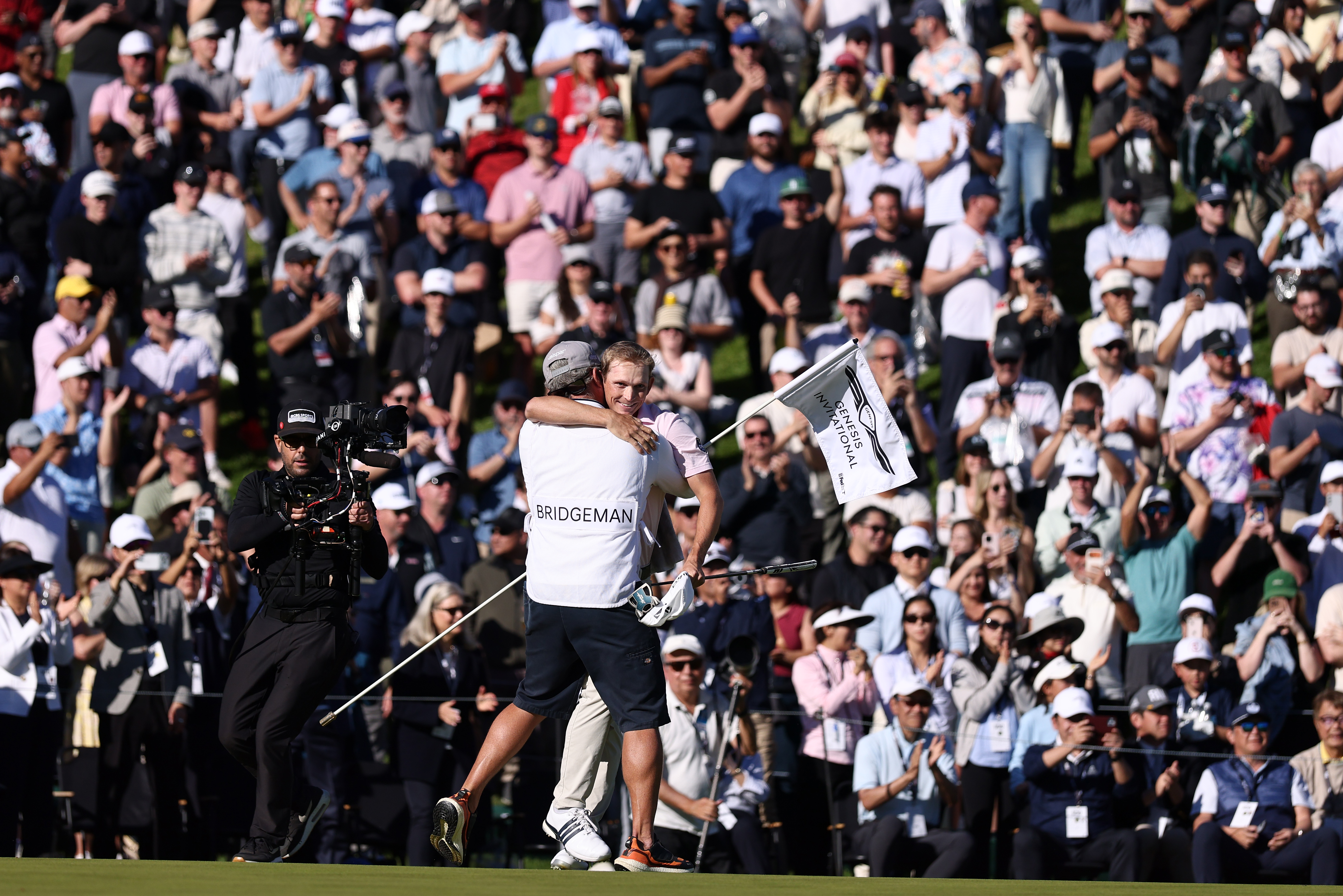 Jacob Bridgeman hugs his caddie on the 18th hole