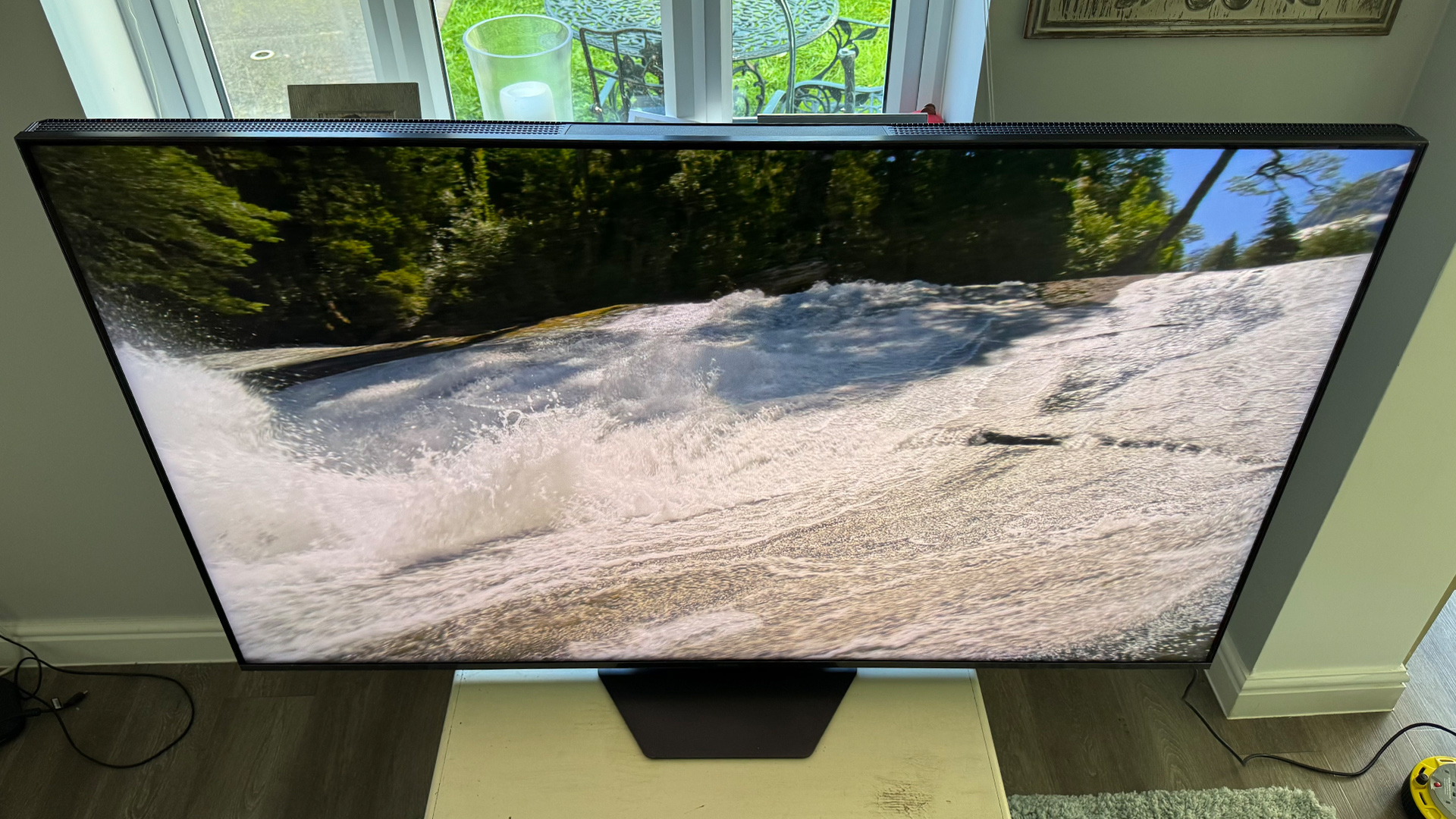 Hisense 65U8QT 4K TV slight top down angle with waves breaking on shoreline on screen